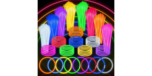 Colorful glow sticks and bracelets arranged in neon rainbow colors on black background