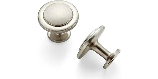 Two brushed nickel cabinet knobs with round, slightly domed tops on a white background