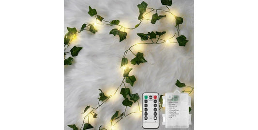 Ivy vine string lights with warm fairy lights on white fur background, remote control and battery box